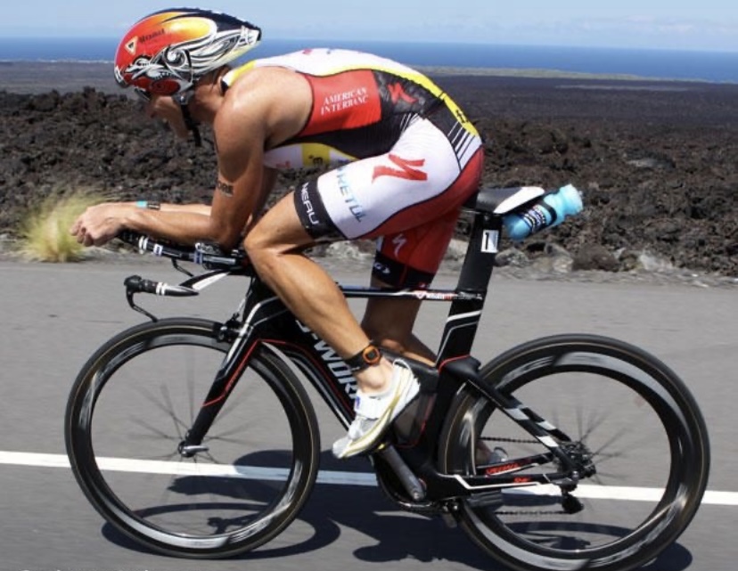 Crowie racing the bike section and a Triathlon on an aero bike