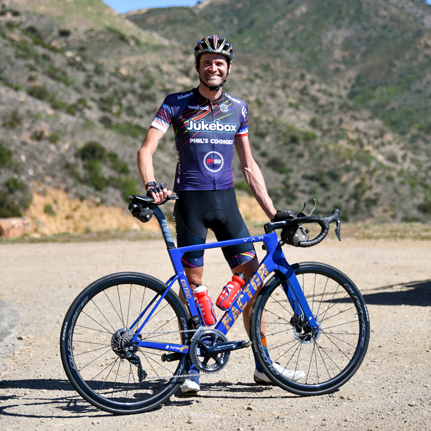 Phil Gaimon standing with his Dura-ace road bike